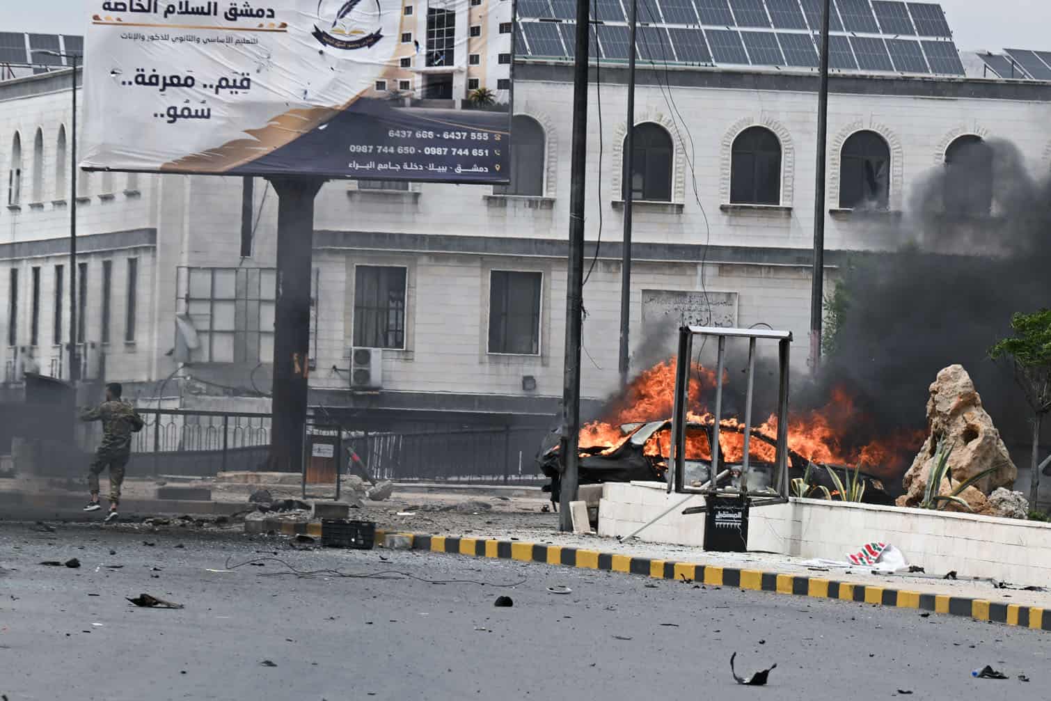 Explosion and fire at a city street with smoke, debris, and emergency response.