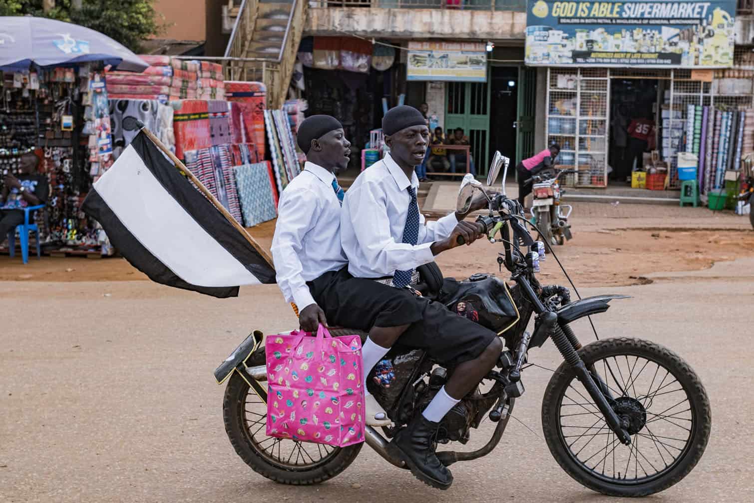 Supporters of a local football team ride on a motorcycle in Padea