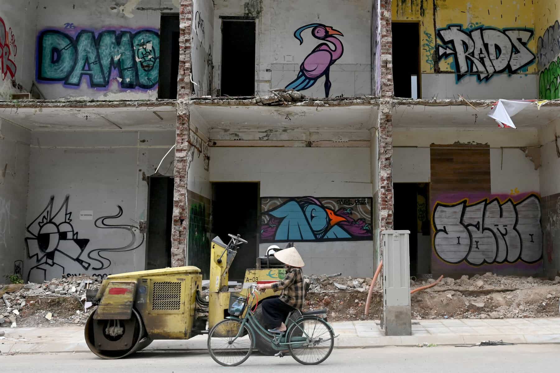 A woman cycles past a demolition site in Hanoi