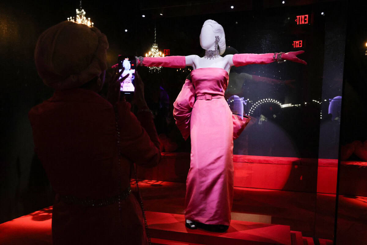 Guests photograph iconic Marilyn Monroes dresses during the Exhibition Preview for