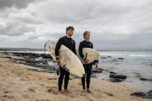 Justin Aucamp (L) and Sarel Wynand Rossouw (R) pose for a portrait with their surfboard in Jeffreys Bay on 7 March 2026.