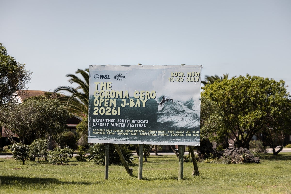 A general view of a road sign for a World Surf League event that was later cancelled stands in Jeffreys Bay on March 7, 2026. Known worldwide simply as "J-Bay", South Africa's surf capital is grappling with uncertainty after losing its place on the World Surf League circuit in 2026. Dozens of surfers bobbed in the waves off Jefferys Bay and a stretch of signs touted surf schools, rentals and B&Bs, evidence of the small South African town's status as a global surf mecca. Its legendary point break secured J-Bay a place on a professional world surfing tour that has for decades drawn the sport's biggest names to this remote corner of the Eastern Cape almost every July. This year, though, the small town is missing out on the international spotlight after the World Surf League (WSL) abruptly pulled the South African stopover from its 2026 Championship Tour. It is a blow to the otherwise humble town of 30,000 inhabitants which made an occasion of an event that booked out its accommodation and brought in millions of dollars, by one estimate. (Photo by ILARIA FINIZIO / AFP)