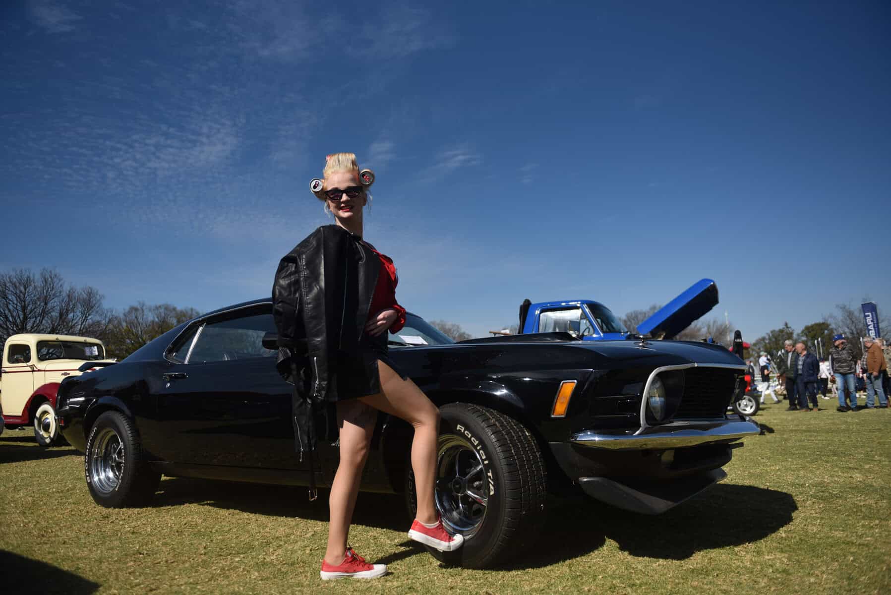 Chanelle Potgieter pose for a photograph next to a Ford Mustang Mach 1