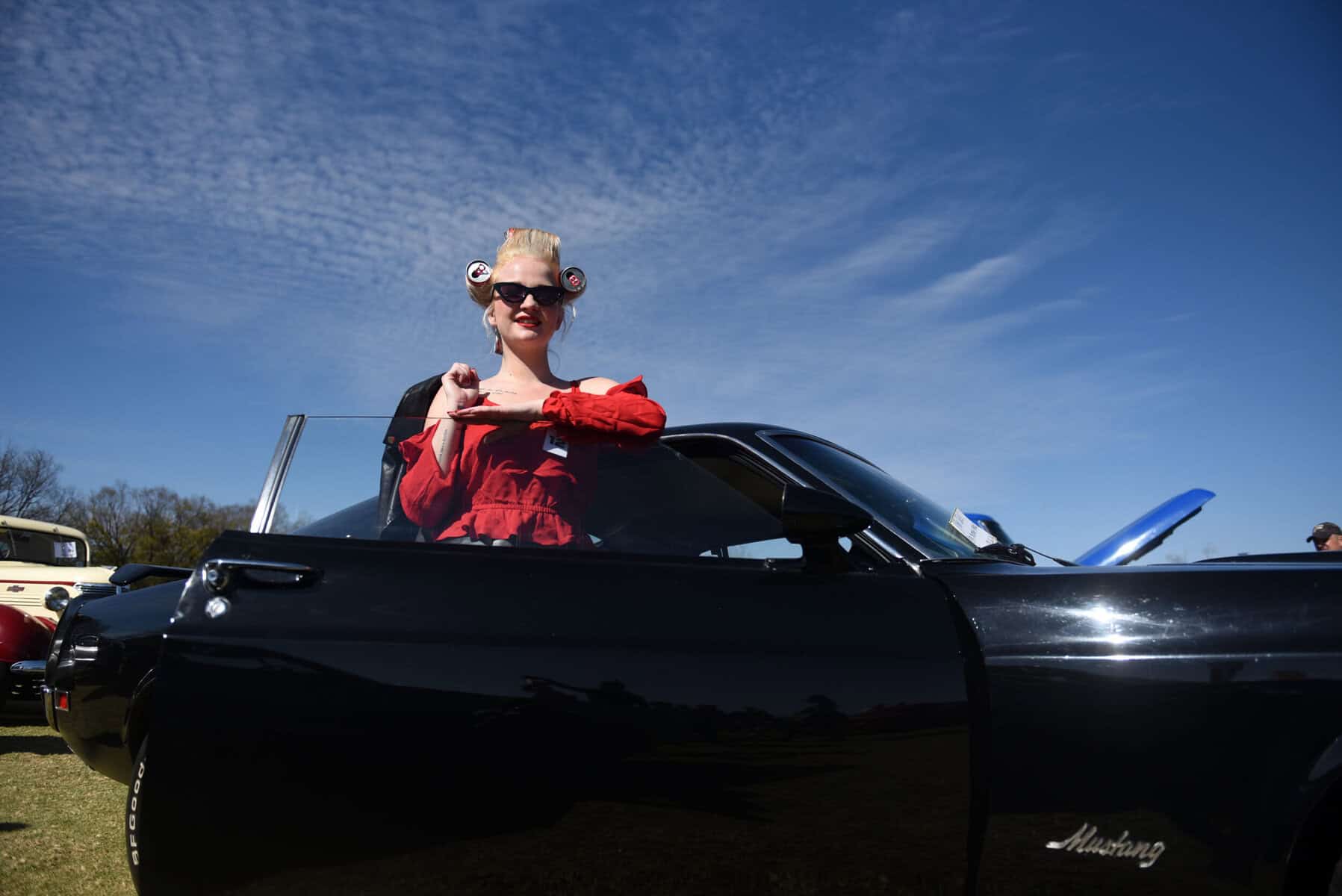 Chanelle Potgieter pose for a photograph next to a Ford Mustang Mach 1