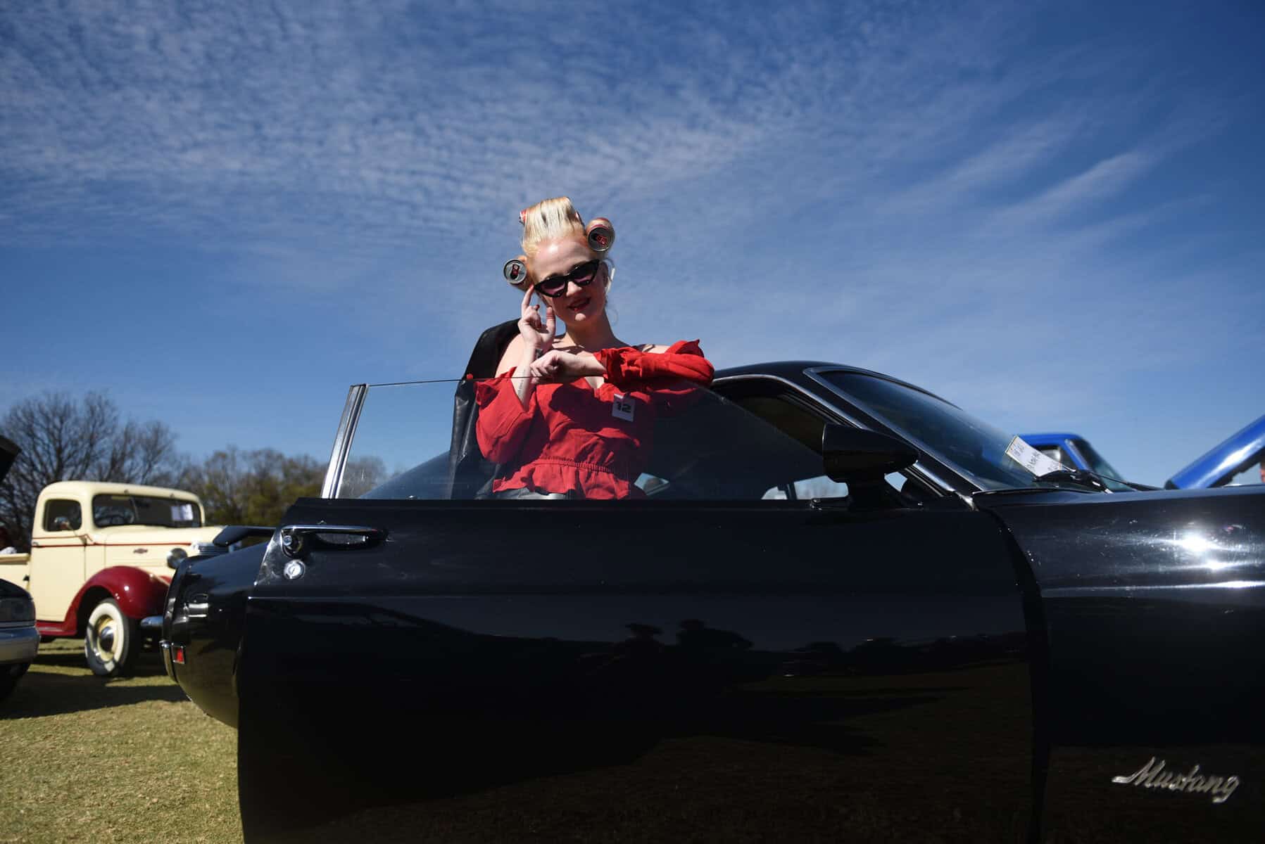 Chanelle Potgieter pose for a photograph next to a Ford Mustang Mach 1