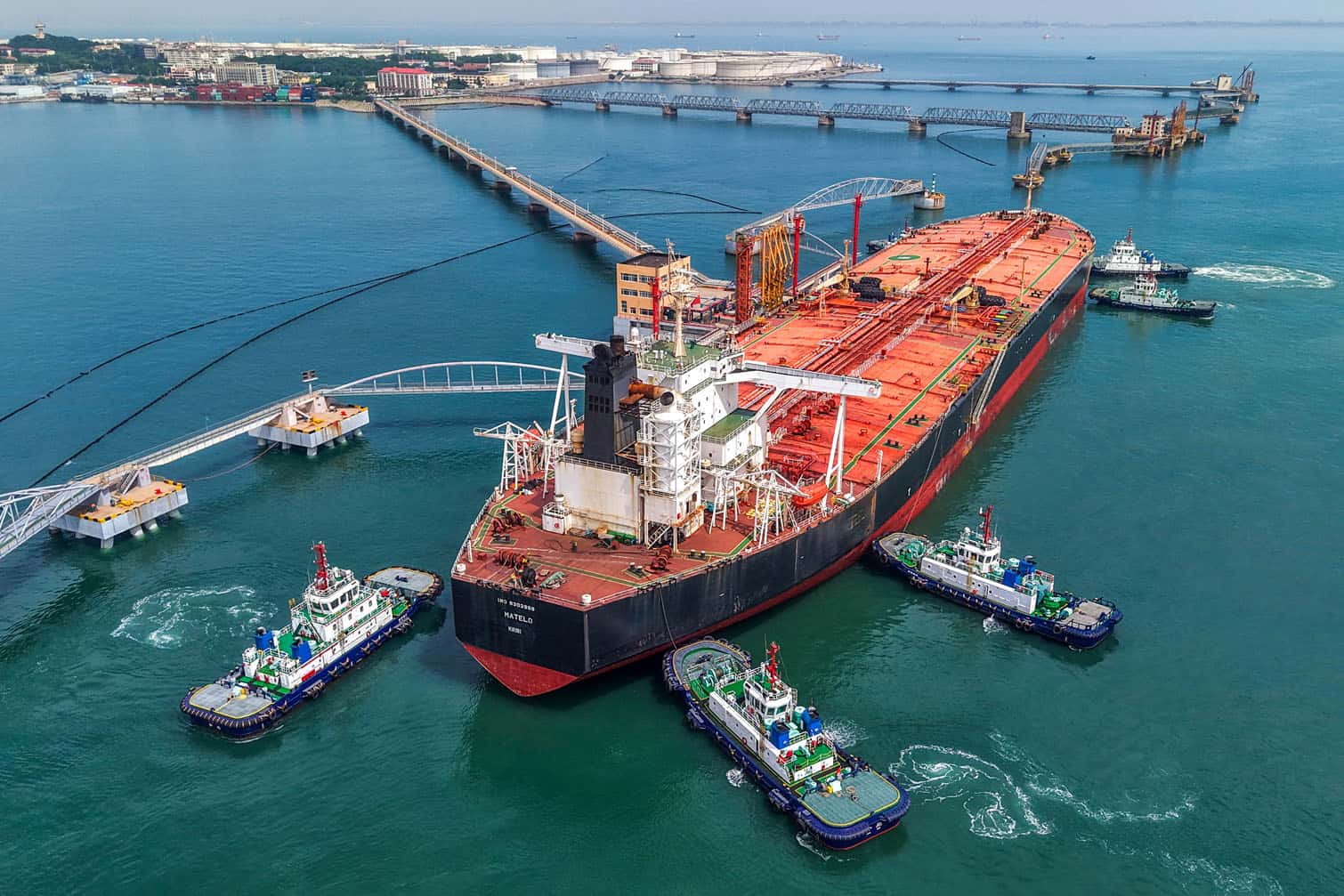 Tugboats move a crude oil tanker