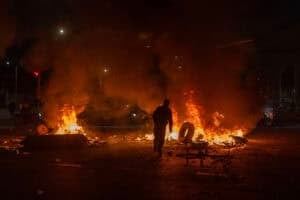 A man throws a tire into a fire
