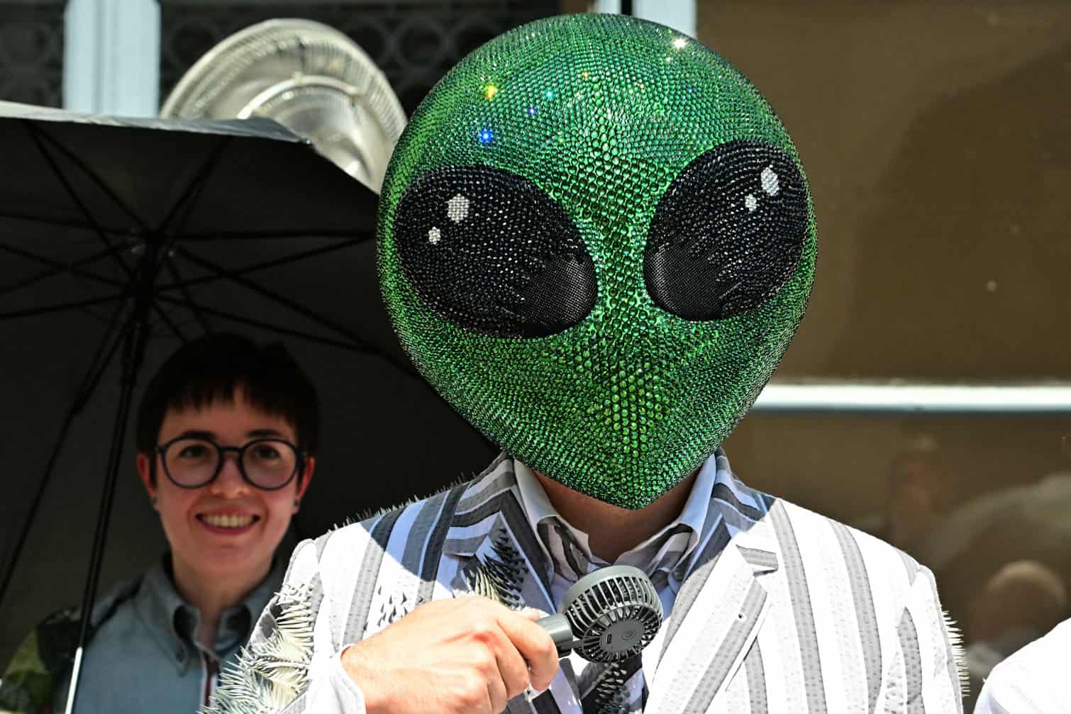 A guest wearing an alien mask