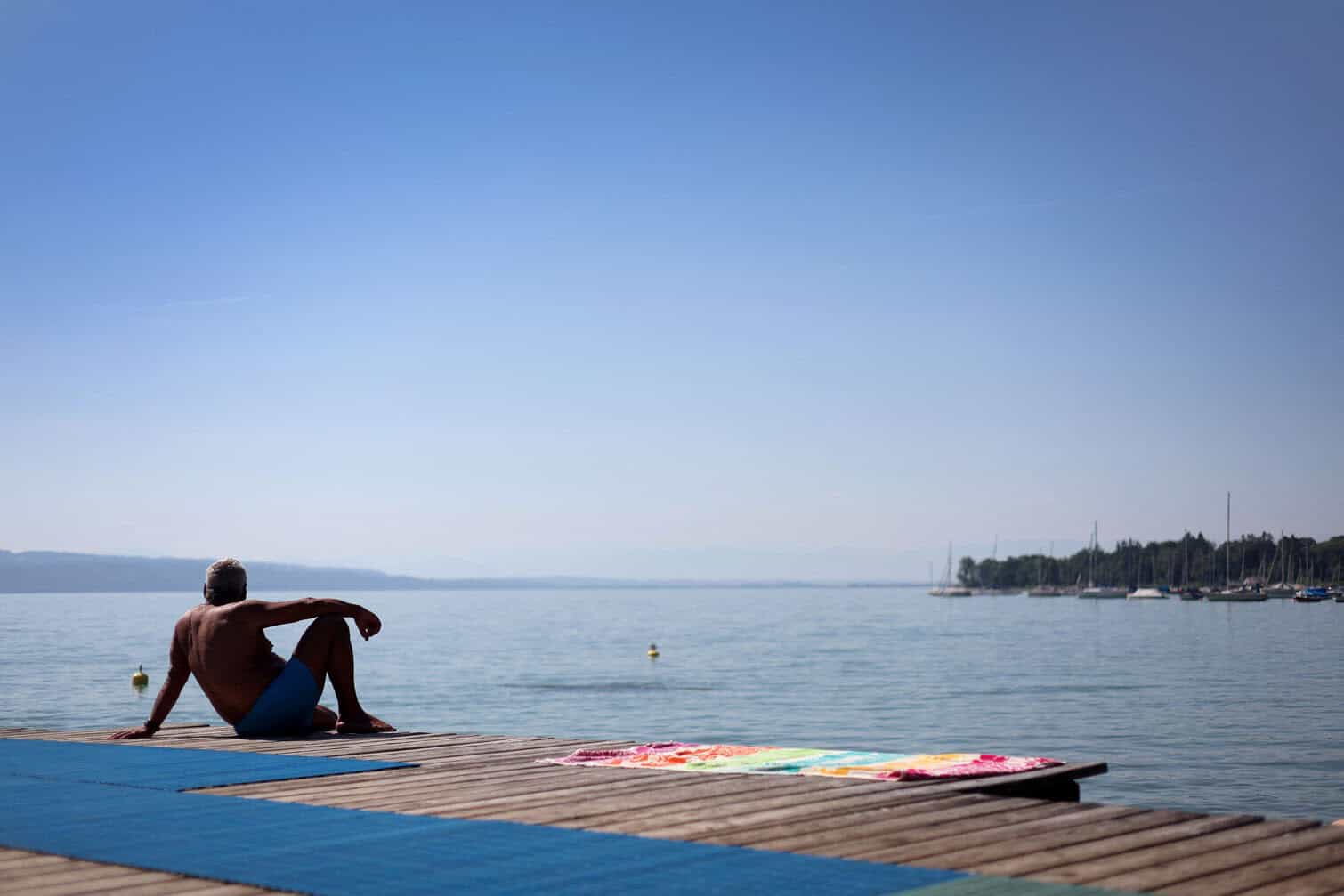 A man is cooling off on a jetty at a lido