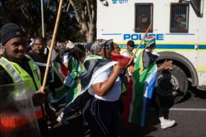 Government urges migrants to report threats as protest tensions mount