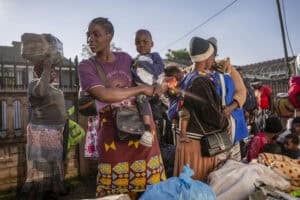 Women are seen with their loads as thousands of Malawian migrants