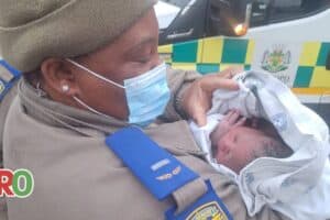 One of the traffic officers holds the newborn baby.