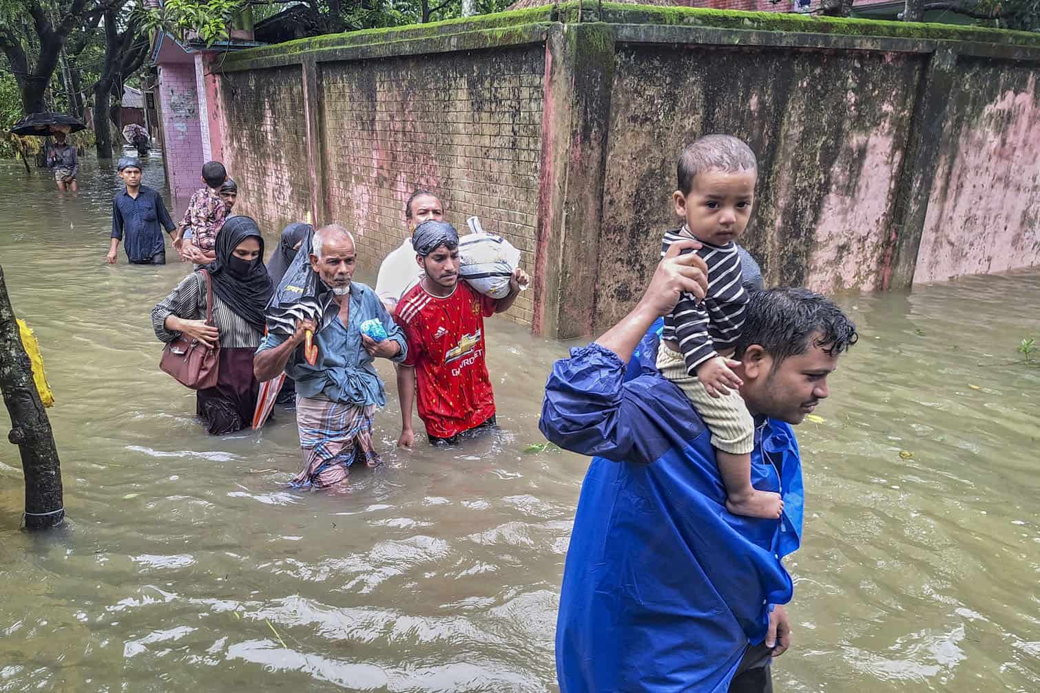 Residents wade through floodwaters