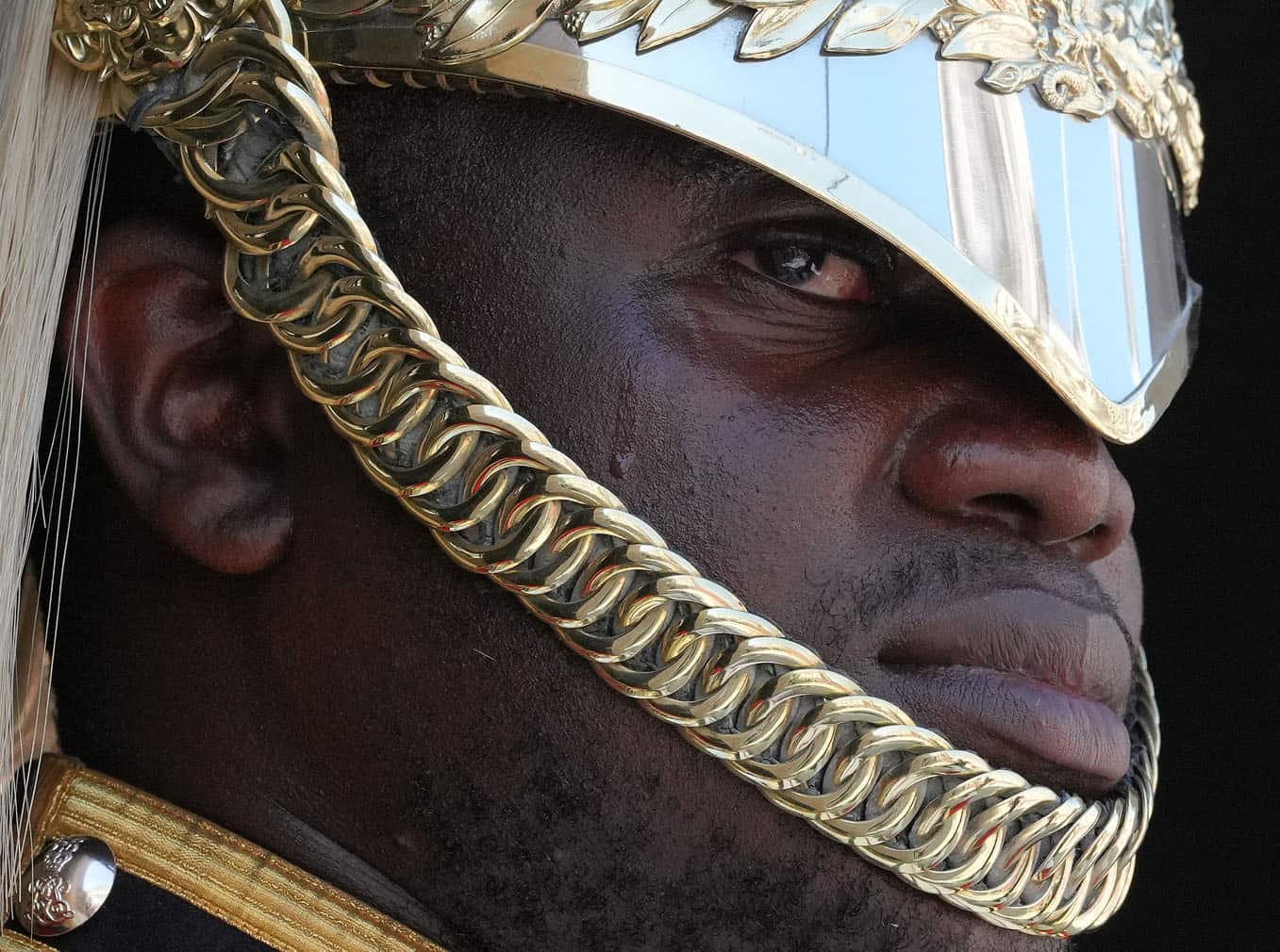 A bead of sweat trickles down the face of a sentry