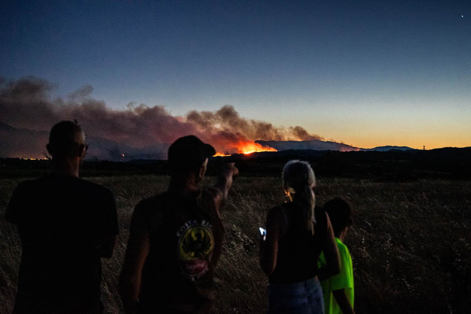 Local residents look at wildfire burning