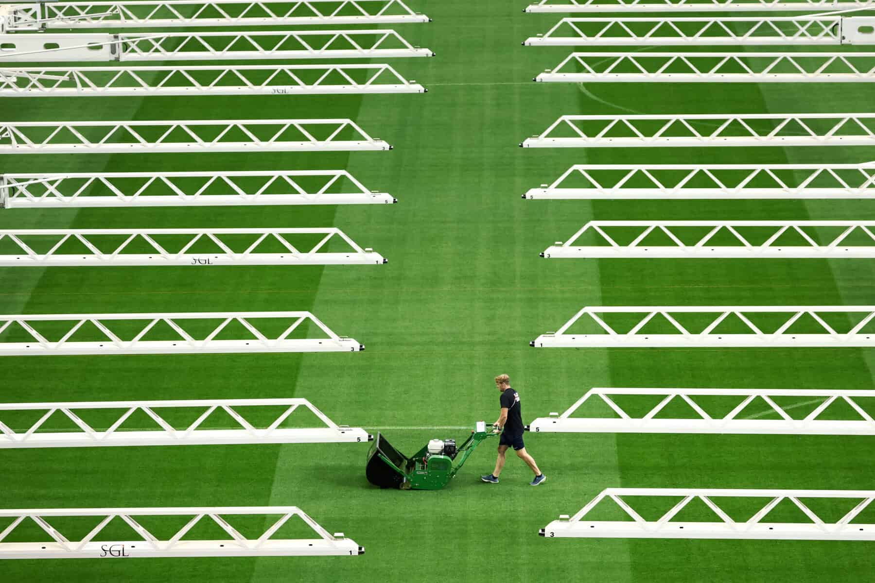A worker cuts the grass at the Dallas Stadium in Arlington