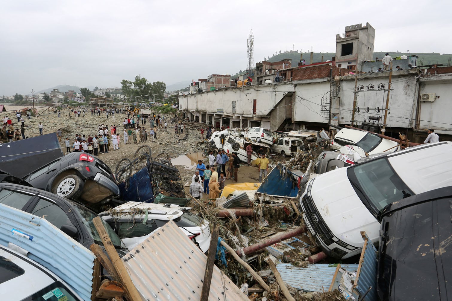 Residents look at damaged vehicles