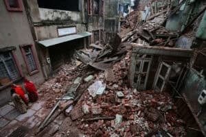 Residents stand near the rubble of a collapsed building