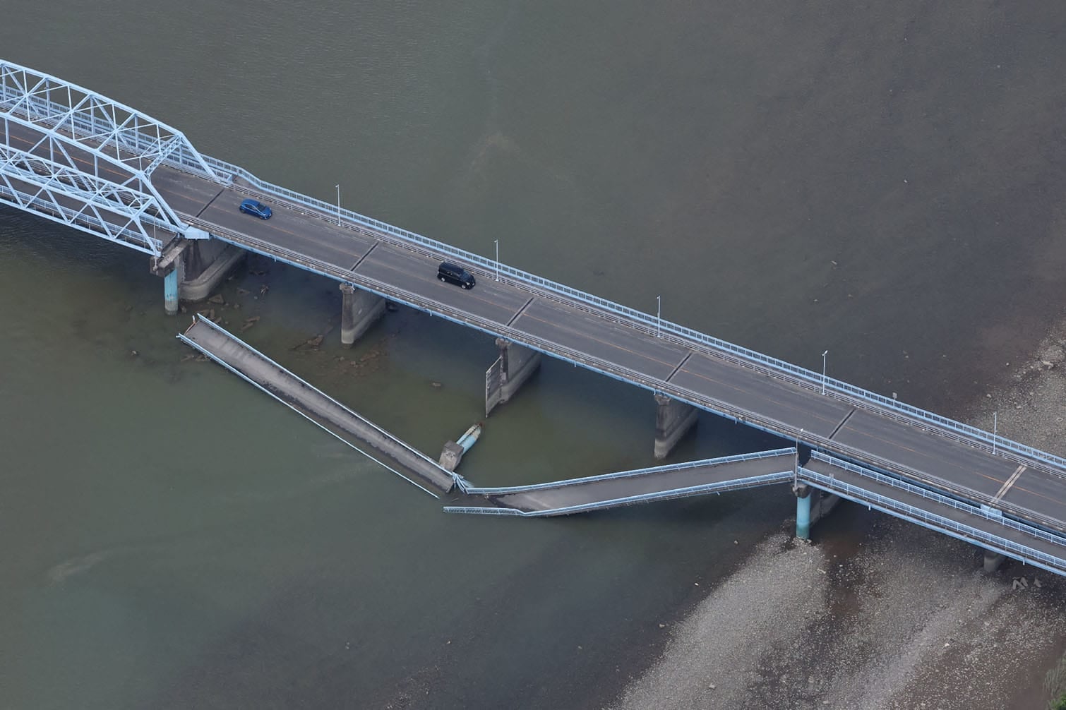 Cars drive on the partially colapsed Ueyanagi Bridge in Yatsushiro, Kumamoto Prefecture, on July 29, 2026, after an earthquake struck southwestern Japan the previous day. (Photo by JIJI PRESS / AFP)
