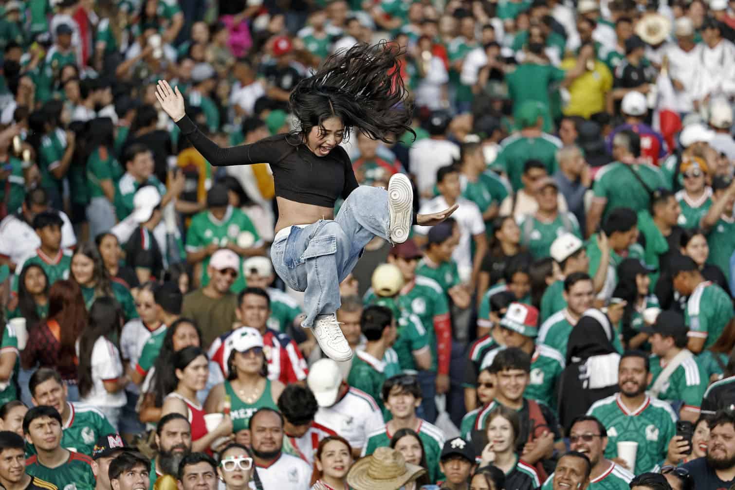 A girl is tossed into the air by Mexican fans
