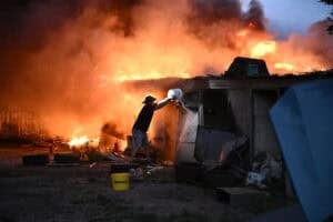 A local resident extinguishes burning garages