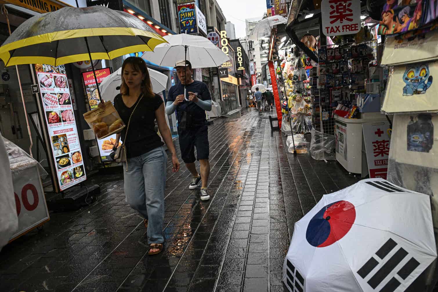 People use umbrellas to shelter