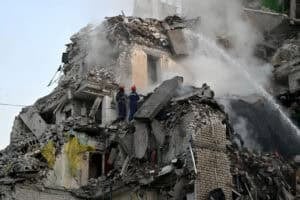 Rescuers extinguish a fire and work in a damaged residential building
