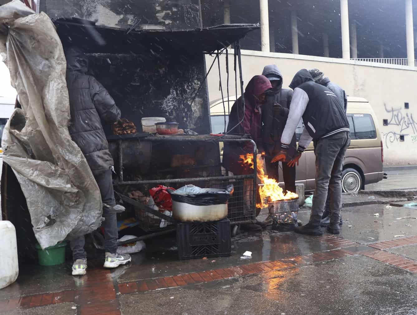 Soweto residents warm themselves next to a chisa nyama during the cold front at Bara Taxi Rank in Soweto on 11 August 2026. Picture: Lerato Thooe