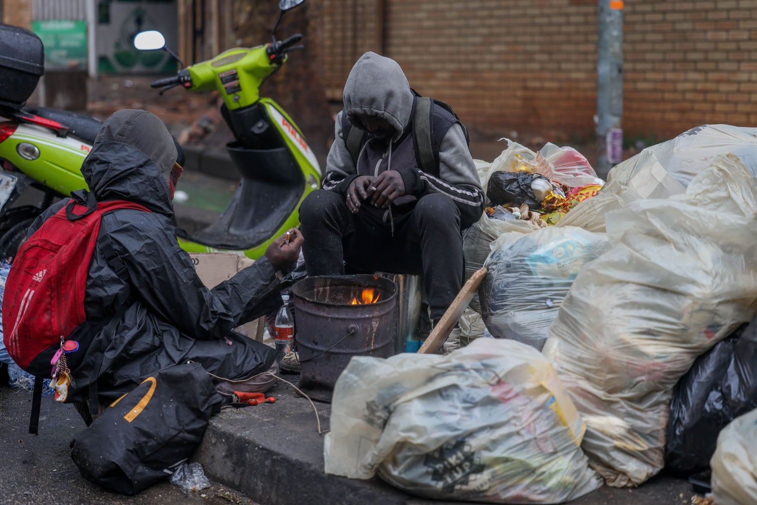 Homeless people endure the cold front on August 11, 2026 in Johannesburg, South Africa. The impacts of the cold front are being felt across parts of the country, with Gauteng experiencing rain falling across the city and temperatures struggling to climb above freezing. The weather service issued an Orange Level 6 warning for disruptive snowfall. (Photo by Gallo Images/Sharon Seretlo)