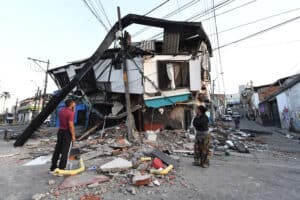 A couple stands amid the rubble