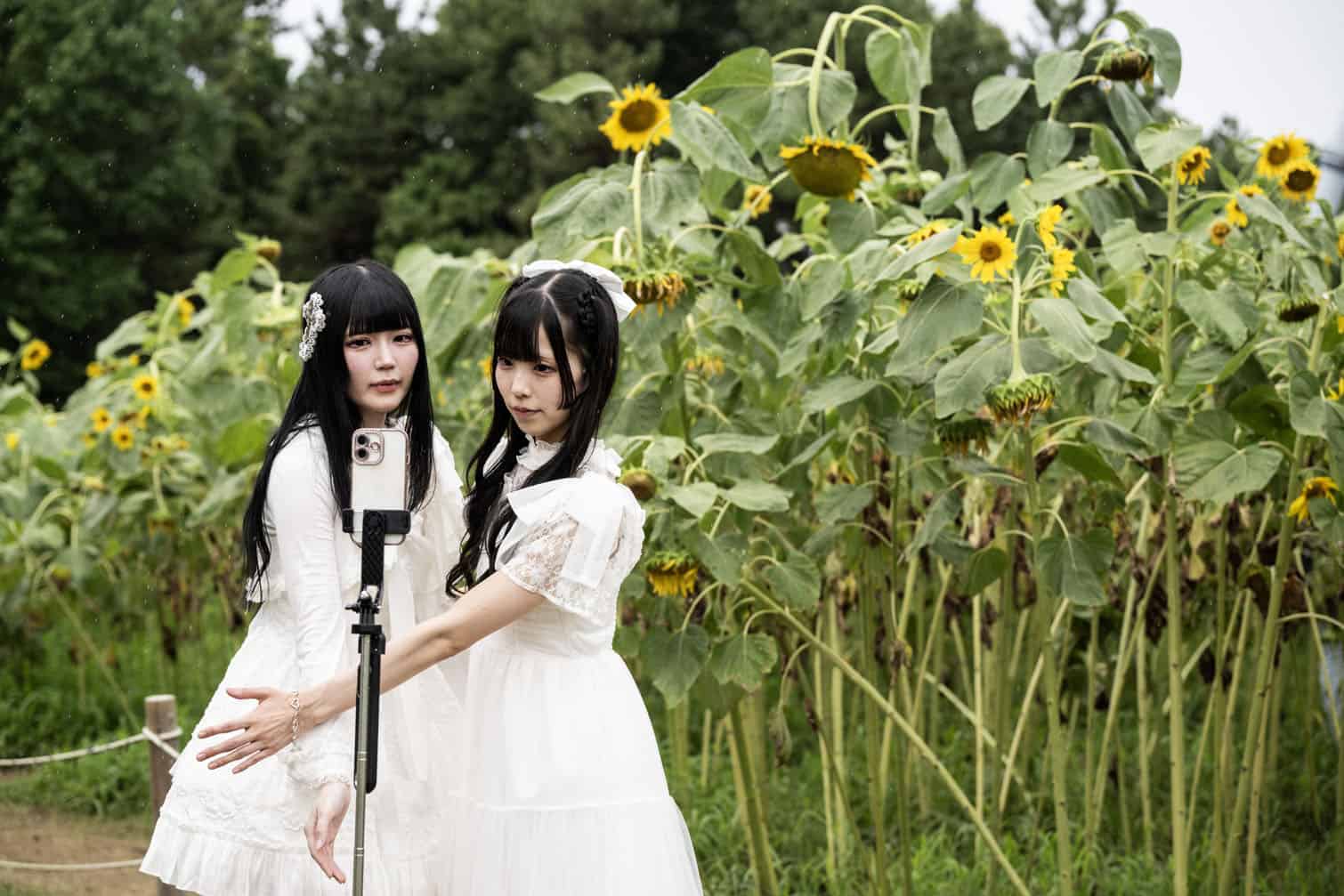 Two women pose for a photo as they visit a sunflower field at Kasai Rinkai Park in Tokyo on August 11, 2026. (Photo by Andrew CABALLERO-REYNOLDS / AFP)