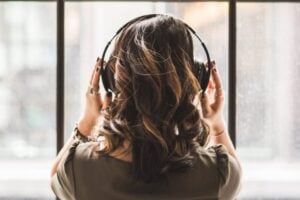 Woman listening to radio by the window on earphones