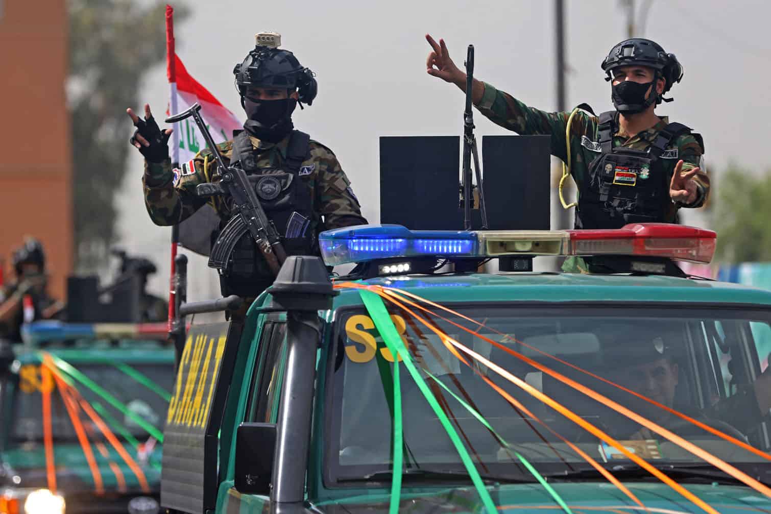 Members of the Iraqi security forces, flash the victory sign during a military parade marking the withdrawal of the US-led coalition from Iraq, in Baghdad on September 30, 2026. A US-led coalition deployed in Iraq more than a decade ago to fight jihadists concluded its mission on September 30, a move celebrated by the country's leaders, but which some fear will embolden pro-Iran armed factions. (Photo by AHMAD AL-RUBAYE / AFP)
