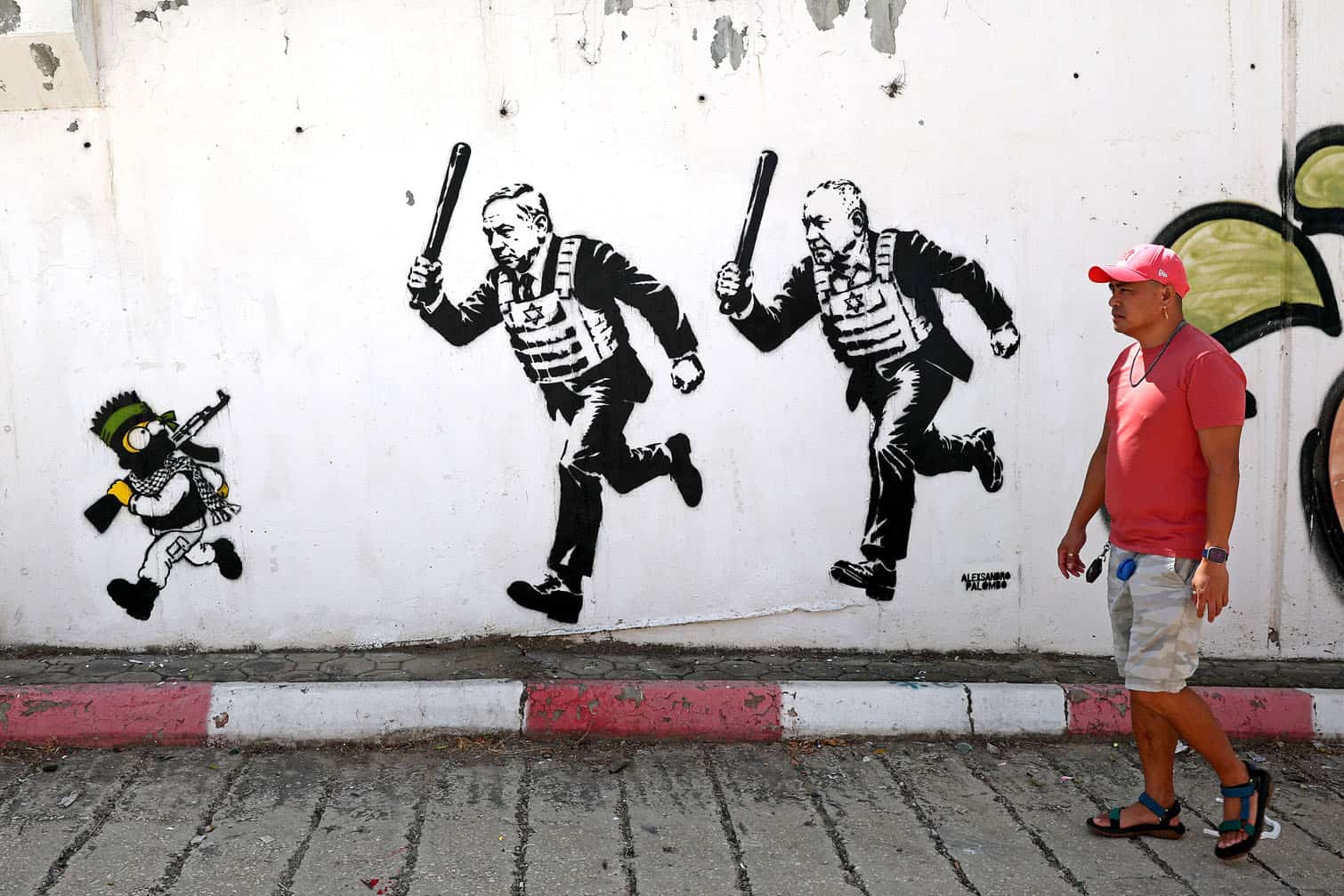 A man walks past a mural titled "RUN" by artist Alexsandro Palombo depicting Israeli Prime Minister Benjamin Netanyahu (C) and politician Gadi Eisenkot wearing bulletproof vests and carrying batons as they chase Bart Simpson, portrayed as a young Hamas fighter, in Tel Aviv on September 29, 2026. (Photo by Jack GUEZ / AFP)