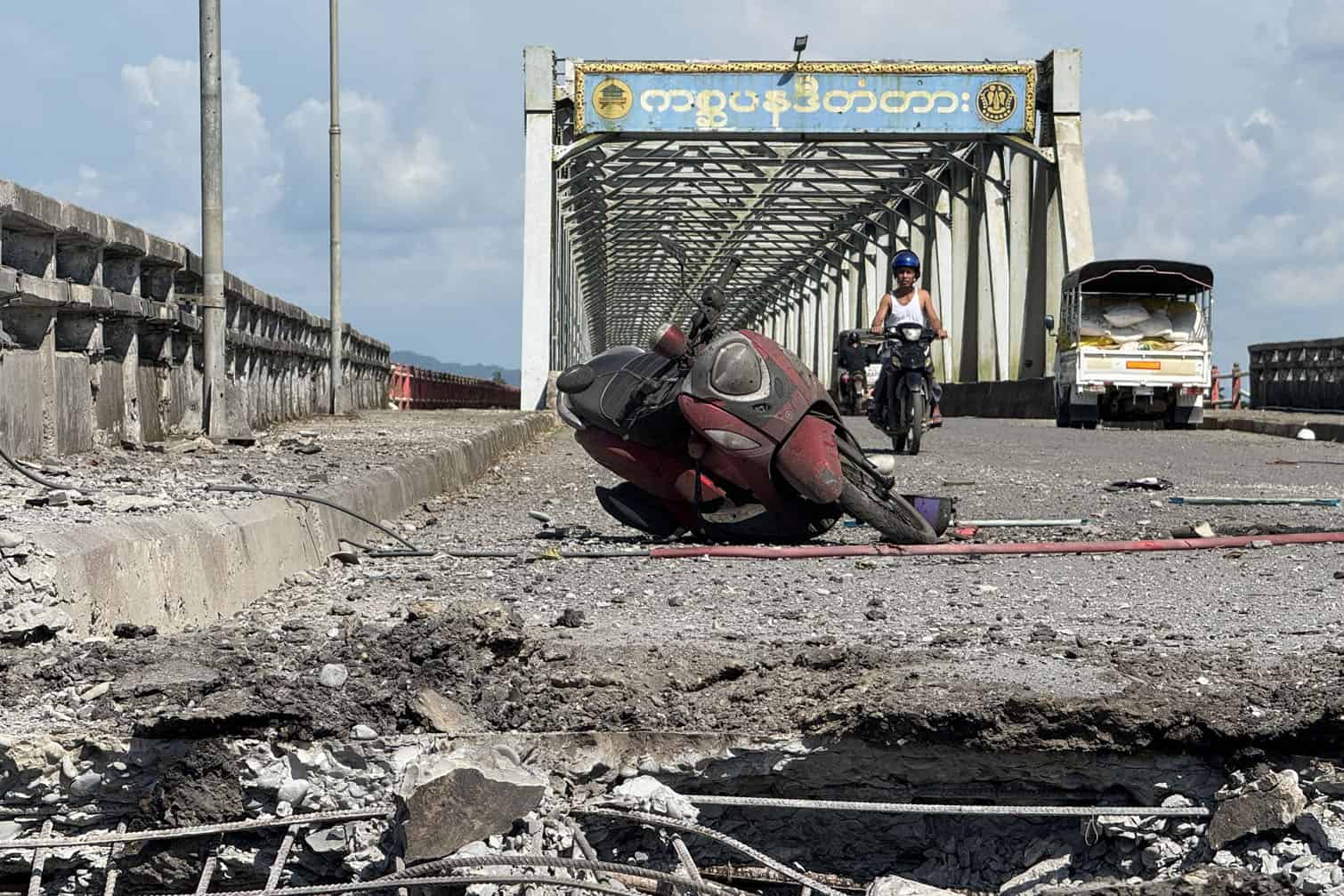 A damaged motorcycle sits on the Kisapanadi Bridge following a military airstrike on a market and the bridge in Kyauktaw, Western Rakhine state on September 28, 2026. A military airstrike on a market in western Myanmar killed 33 people on September 28 and wounded 36 more, a rebel faction which controls the area said in a statement. (Photo by AFP)