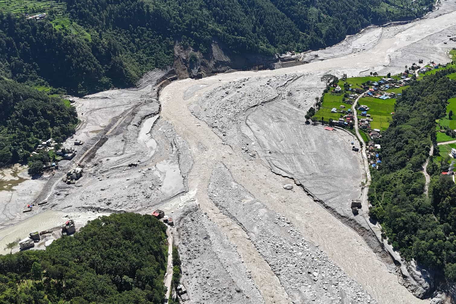 An aerial view shows damaged houses covered in sludge in the aftermath of the August 26 flash flood, at Betrawati Bazaar in Nepal's Rasuwa district on September 28, 2026. The Himalayan nation suffered one of the worst catastrophes in its history late last month when a tsunami-like flood, triggered by a high-altitude glacial mountain collapse along the Nepal-China border, cut a swathe of destruction claiming more than 1,400 lives and leaving 5,000 unaccounted for. (Photo by PRAKASH MATHEMA / AFP)