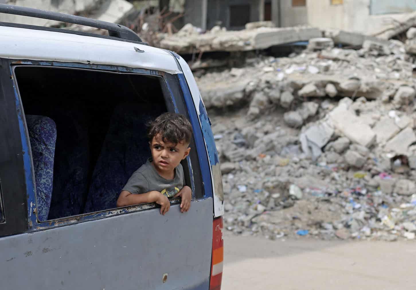 A boy looks out of a vehicle window during a mass funeral at the Nuseirat refugee camp in the central Gaza Strip on September 29, 2026, following the recovery of 41 bodies from the rubble of a residential building hit in an Israeli strike at the start of the war in October 2023. (Photo by Eyad Baba / AFP)