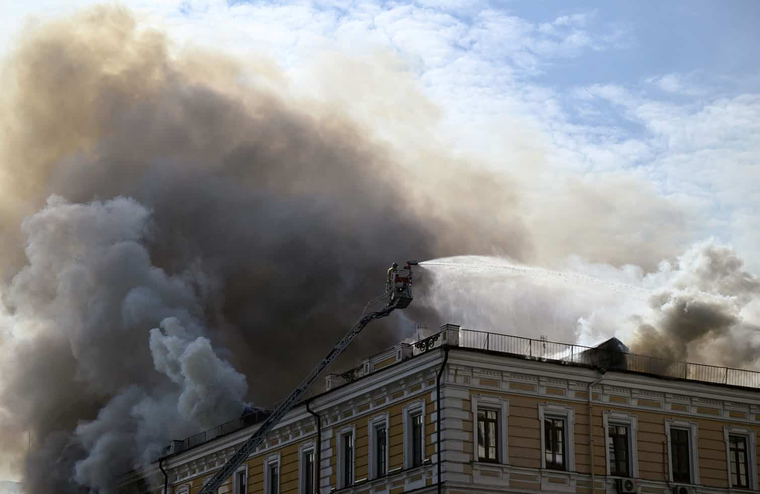 A firefighter tackles a blaze engulfing a building of the Ukrainian Academy of Science which was hit by a Russian drone in the centre of Kyiv on September 28, 2026, amid the Russian invasion of Ukraine. (Photo by Genya SAVILOV / AFP)
