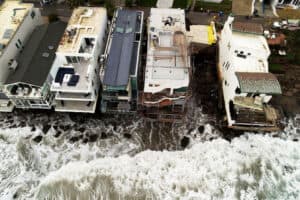 waves crashing on seaside homes in Malibu