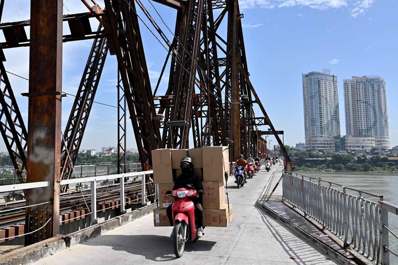A man rides a motorbike carrying boxes across Long Bien Bridge in Hanoi on September 29, 2026. (Photo by Nhac NGUYEN / AFP)