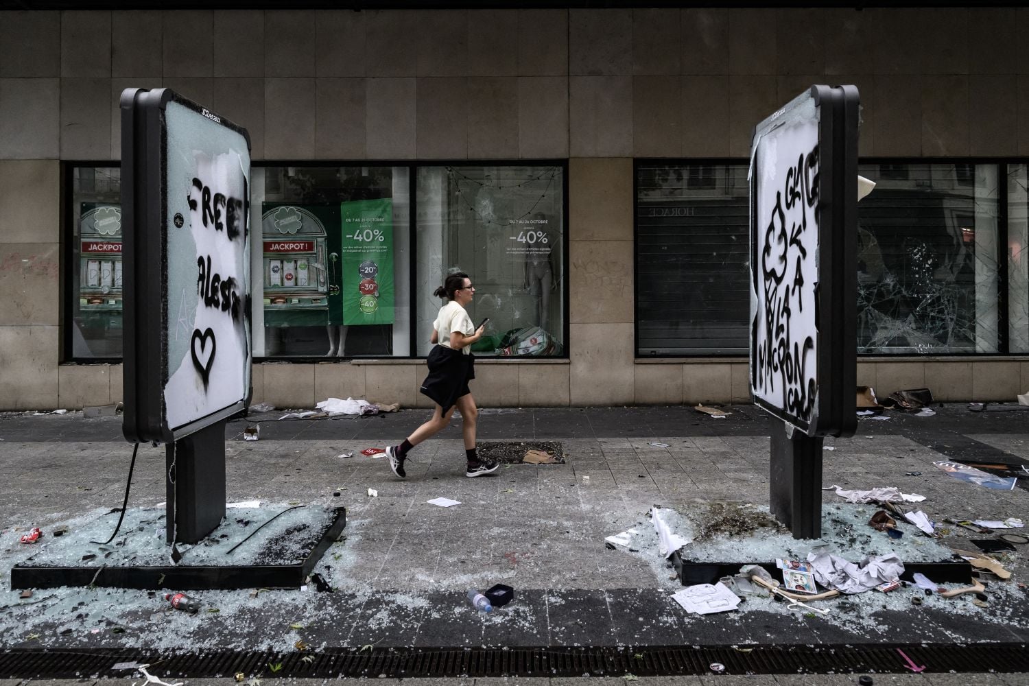 A pedestrian runs past damage and broken storefront windows of a shop a day after riots and looting following a nationwide protest against the "high cost of living" in Lyon, central-eastern France, on 18 October 2026. Picture: JEFF PACHOUD / AFP
