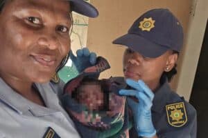 Police officers with the newborn baby of a suspect delivered at a police station.