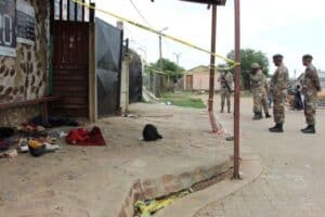 SANDF members standing in front of the tavern. Shoes and other belongings of the deceased and injured were still lying on the stoep.