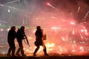 Riot police officers take cover