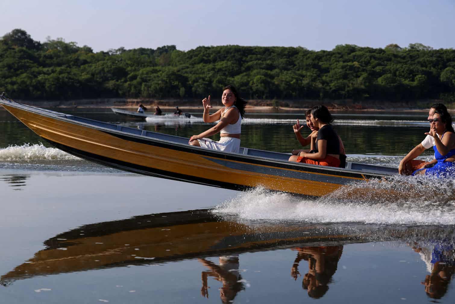 Indigenous people from the Kambeba tribe travel on a boat from Tres Unidos Indigenous community to vote in Sao Sebastiao community, in rural Manaus, Amazonas State, northern Brazil, during the presidential election on October 4, 2026. Brazilians head to the polls in a highly polarized presidential election between incumbent leftist President Luiz Inacio Lula da Silva -seeking a fourth presidential mandate- and right-wing senator Flavio Bolsonaro, who emerged as the leading figure of the conservative movement following the conviction and imprisonment of his father, former president Jair Bolsonaro. (Photo by Michael DANTAS / AFP)