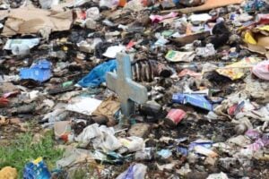 A gravestone barely sticking out of the rubbish.