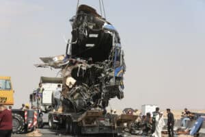 A crane lifts the wreckage of a tour bus