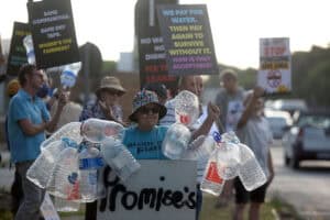 Kensington resident Charmaine Partridge carries empty water bottles
