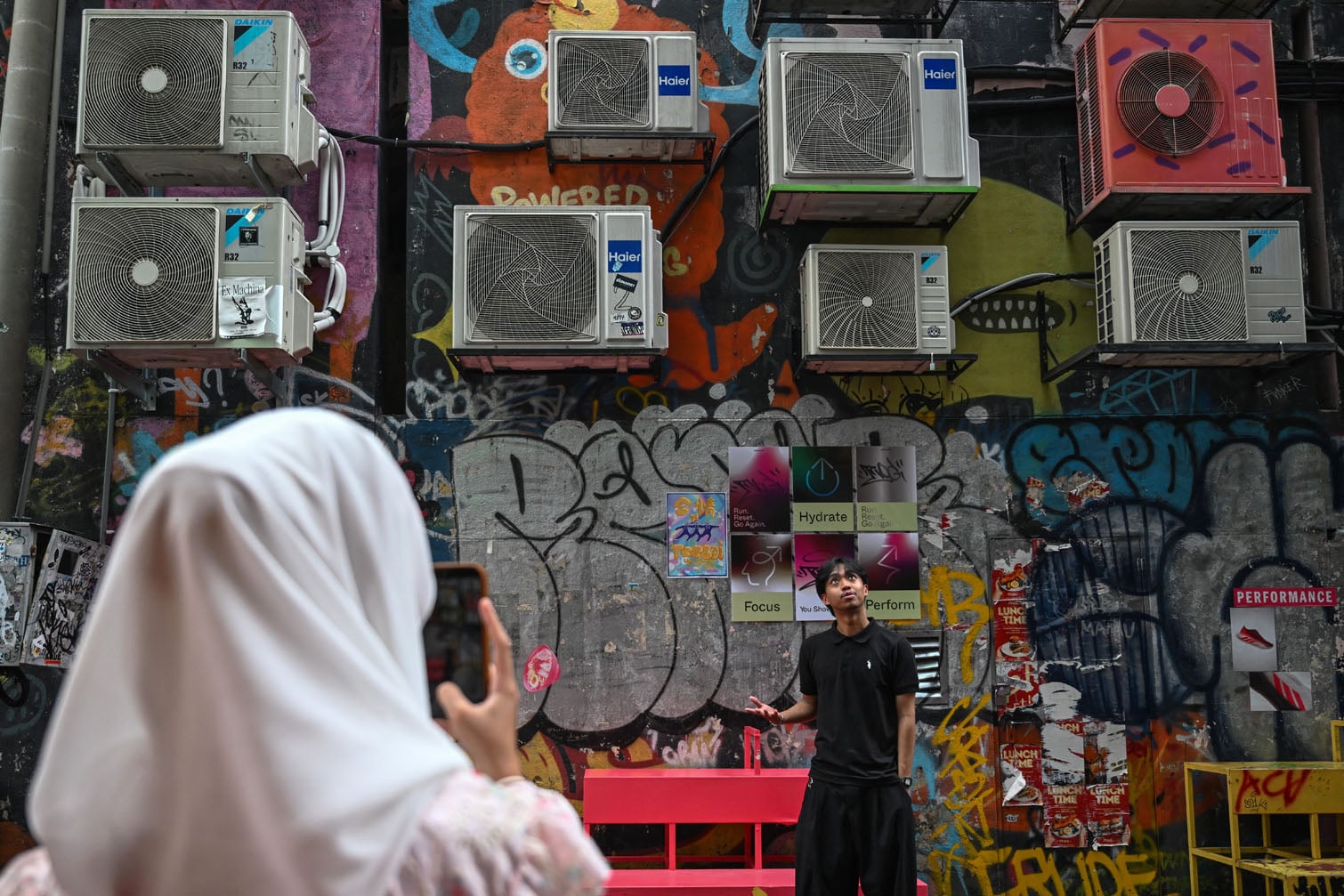 A man poses for a photo outside a creative community hub in Chinatown in Kuala Lumpur on October 18, 2026. (Photo by Jam STA ROSA / AFP)