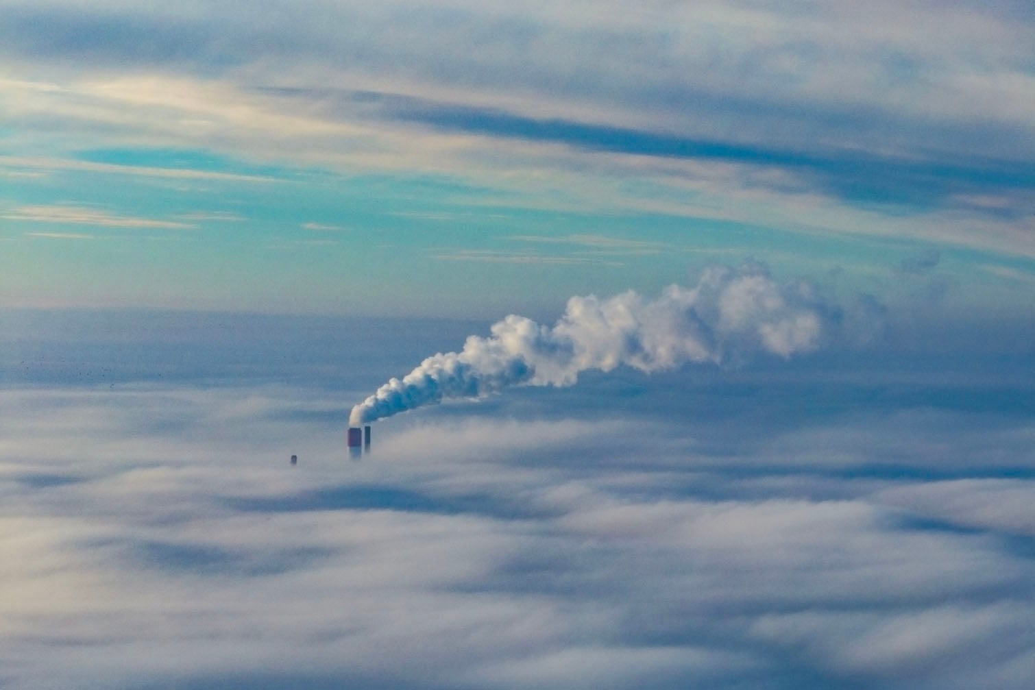 This aerial photograph taken on October 18, 2026 shows steam rising from a chimney shrouded in a blanket of fog on an autumn morning in Warsaw, Poland. (Photo by Sergei GAPON / AFP)